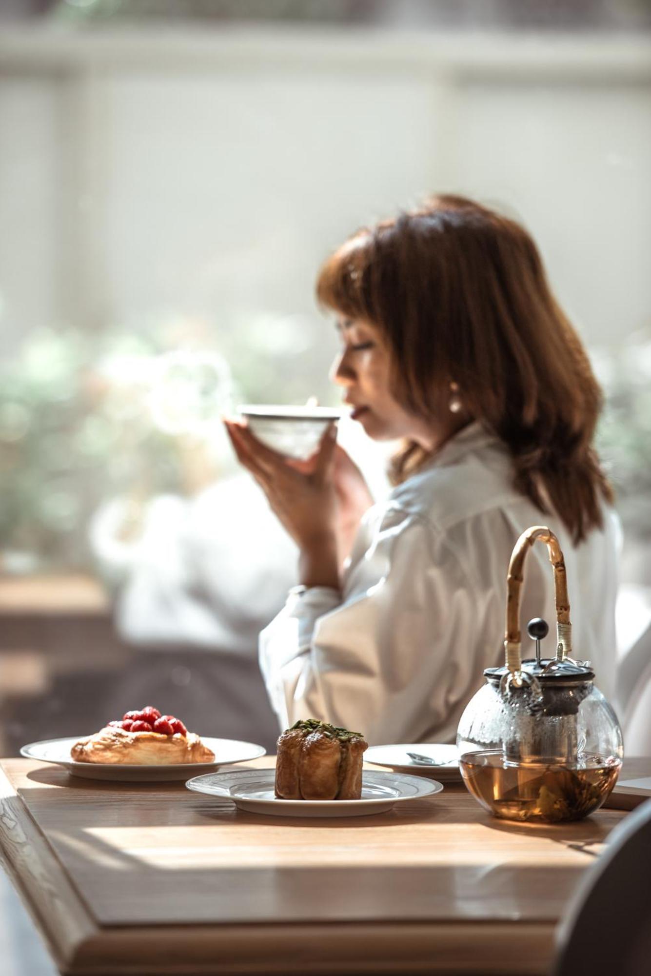 杜斯特多哈酒店 外观 照片 A woman drinking tea